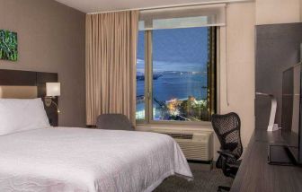 King bedroom with working station and city view at the Hilton Garden Inn Financial Center Manhattan Downtown, NY.