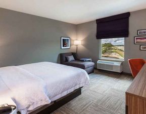 comfortable king room with TV, lounge area, and work desk ideal for working remotely at Hampton Inn Bulverde Texas Hill Country.