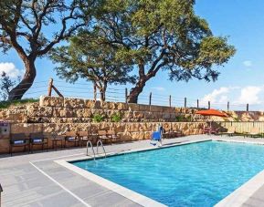 beautiful outdoor pool with comfortable seating area at Hampton Inn Bulverde Texas Hill Country.
