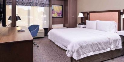 Comfortable king size bed in a hotel room at the Hampton Inn Albuquerque, University-Midtown (UNM).
