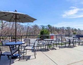 Outdoor patio with tables, chairs and sun umbrellas at the Hampton Inn Boston-Peabody.