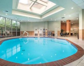 bright-lit indoor pool with sun rooff and comfortable seating area at Embassy Suites by Hilton Seattle Tacoma International Airport.