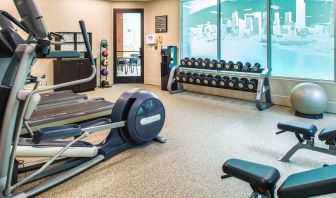 Fully equipped fitness center with treadmills and weights at at Embassy Suites by Hilton Seattle Tacoma International Airport.
