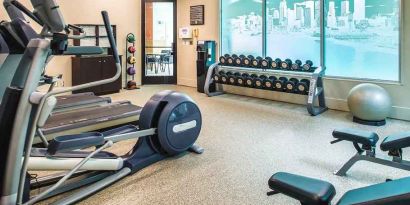 Fully equipped fitness center with treadmills and weights at at Embassy Suites by Hilton Seattle Tacoma International Airport.