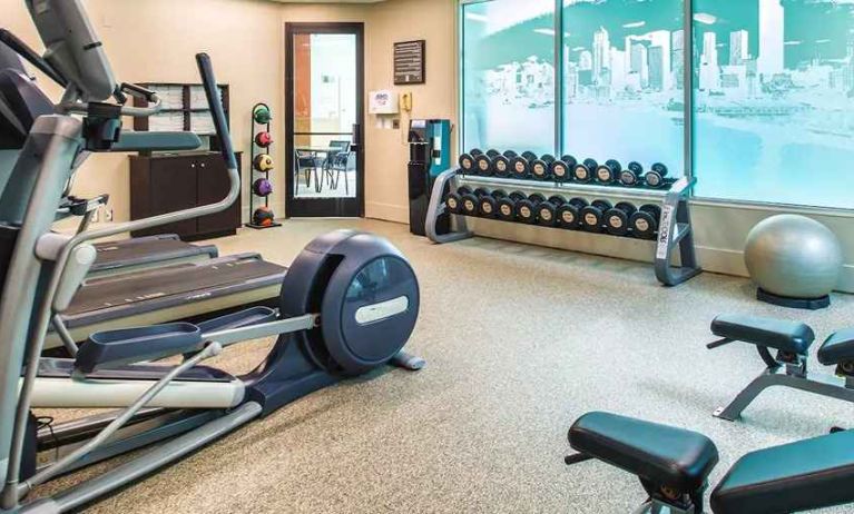 Fully equipped fitness center with treadmills and weights at at Embassy Suites by Hilton Seattle Tacoma International Airport.