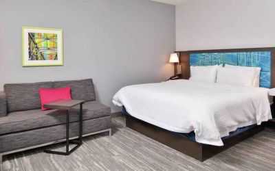 King bedroom with sofa at the Hampton Inn & Suites St. Paul Oakdale/Woodbury by Hilton.