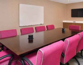 Small meeting room with pink chairs at the Hampton Inn & Suites St. Paul Oakdale/Woodbury by Hilton.