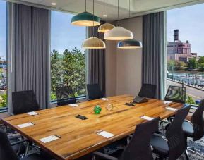 Bright meeting room with windows at the Hampton Inn Boston Seaport District.