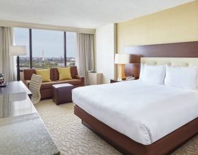 Bright king bedroom with sofa, window and desk at the DoubleTree by Hilton Washington DC - Crystal City.