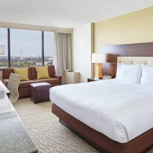 Bright king bedroom with sofa, window and desk at the DoubleTree by Hilton Washington DC - Crystal City.