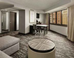 Spacious living room with sofa and working station at the Embassy Suites by Hilton Crystal City National Airport.