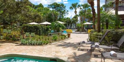 Beautiful outdoor patio with plants by the pool at the DoubleTree Suites by Hilton Orlando - Disney Springs Area.