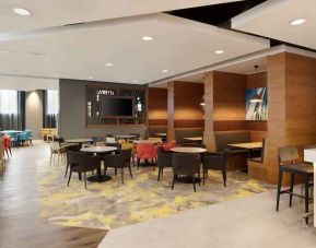 Lobby workspace with tables and chairs at the Hampton by Hilton London Docklands.
