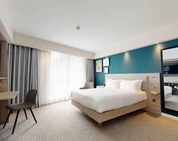 Bright and spacious king suite with working station at the Hampton by Hilton Manchester Northern Quarter.