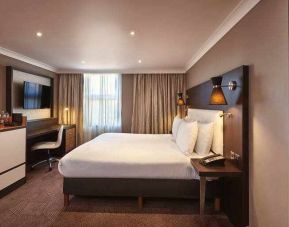 King bedroom with TV screen and desk at the DoubleTree by Hilton London - Ealing.
