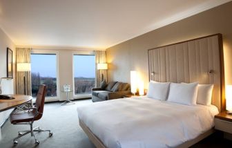 King guestroom with desk and sofa at the Hilton London Heathrow Airport Terminal 5.