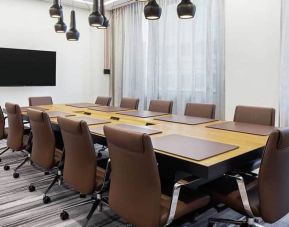 Spacious meeting room with 3 sets of tables and chairs and projector screen at the Canopy by HIlton Atlanta Midtown