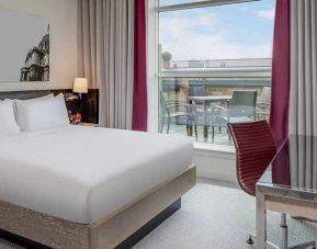 comfortable delux king bed with lots of natural light, work desk, and outside terrace at Hilton London Angel Islington.