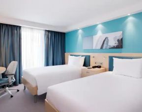 Twin room with TV screen and desk at the Hampton by Hilton Bristol Airport.