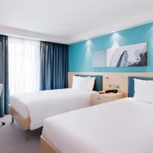 Twin room with TV screen and desk at the Hampton by Hilton Bristol Airport.