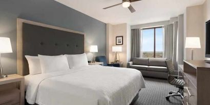Spacious king suite with work area and TV at Homewood Suites by Hilton University City Philadelphia, PA.