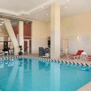 Lovely indoor pool with surrounding seating area and sun beds at Homewood Suites by Hilton University City Philadelphia, PA.