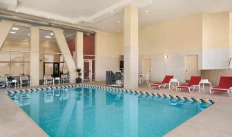 Lovely indoor pool with surrounding seating area and sun beds at Homewood Suites by Hilton University City Philadelphia, PA.