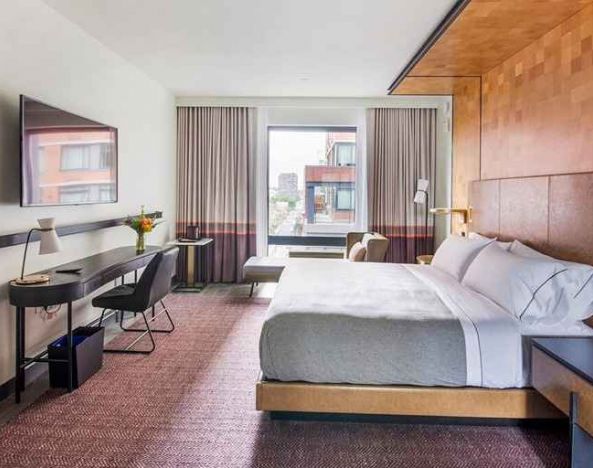spacious king room with work desk and TV at Canopy by Hilton Jersey City Arts District.