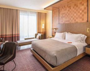 comfortable king room with TV, work desk, and lounge area at Canopy by Hilton Jersey City Arts District.