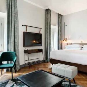 Spacious king bedroom with desk and TV screen at the DoubleTree by Hilton Rome Monti.