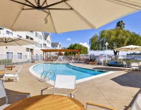 lovely outdoor pool with shaded seating area at Homewood Suites by Hilton Oakland-Waterfront.