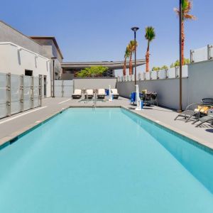 large outdoor pool with sunbeds and outdoor seating at Hampton Inn Irvine Spectrum Lake Forest.