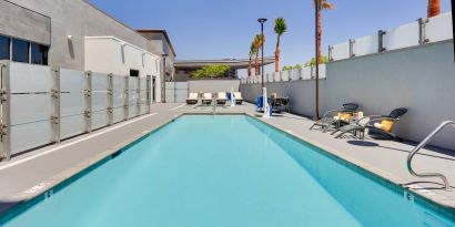 large outdoor pool with sunbeds and outdoor seating at Hampton Inn Irvine Spectrum Lake Forest.