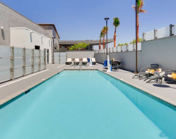 large outdoor pool with sunbeds and outdoor seating at Hampton Inn Irvine Spectrum Lake Forest.
