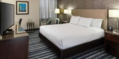 Comfortable king room with TV and work desk ideal for working remotely at DoubleTree by Hilton Hotel Wilmington.