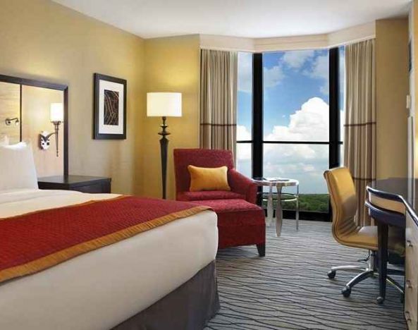 beautiful king suite with TV and work desk with lots of natural light at Hilton Rosemont/Chicago O'Hare.