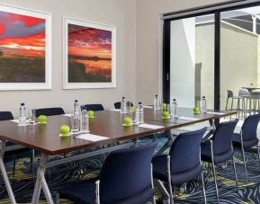 Small meeting room with rectangular table and seating for 8 guests.