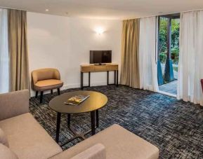 Suite living room with sofa and desk at the Morrison, a DoubleTree by Hilton Hotel.