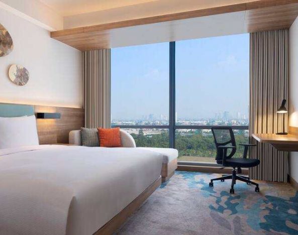 King bedroom with desk along the window at the Hilton Garden Inn Jakarta Taman Palem.