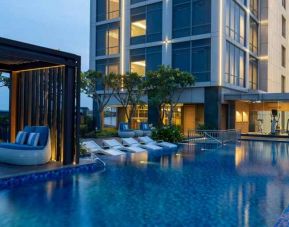 Beautiful outdoor pool area with lounges at the Hilton Garden Inn Jakarta Taman Palem.