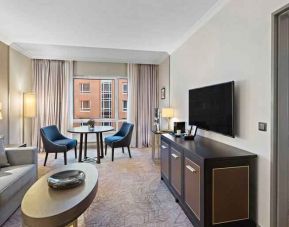 Spacious living room with working station by the window at the Hilton Munich City.