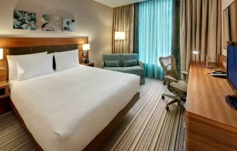 Queen room with desk and sofa at the Hilton Garden Inn Frankfurt Airport.