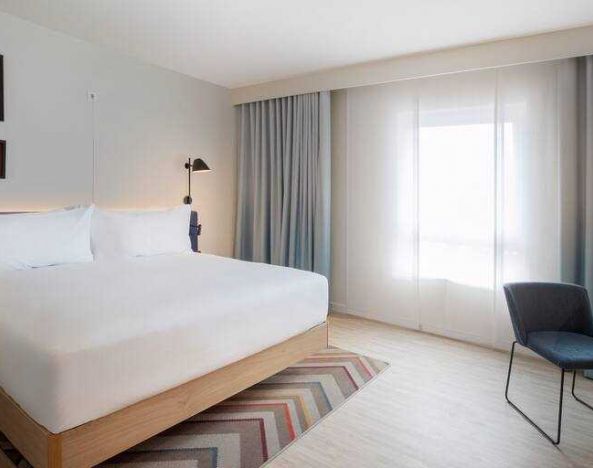 Bright guest room with king size bed at the Hampton by Hilton Kaiserslautern.