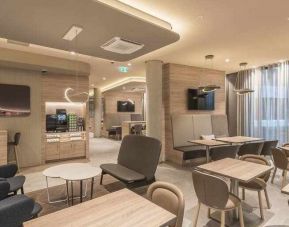 Dining area with chairs and tables at the Hampton by Hilton Frankfurt Airport.