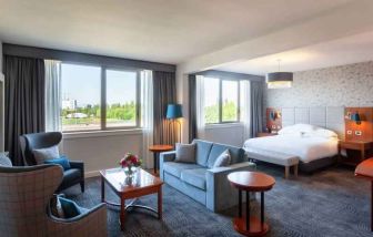 Spacious king suite with living room and working station at the Hilton Strasbourg.