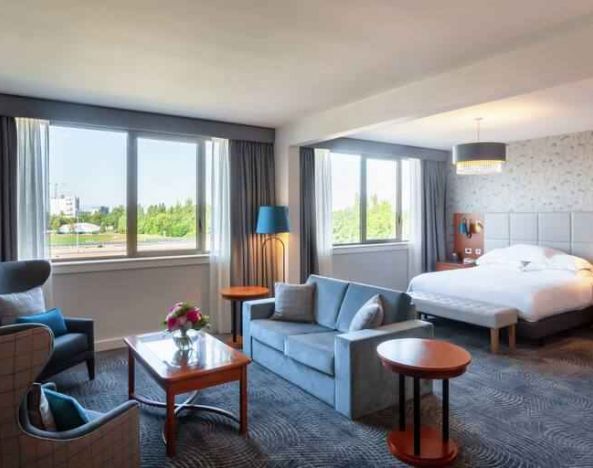 Spacious king suite with living room and working station at the Hilton Strasbourg.