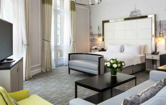 Spacious hotel suite with sofa and TV screen at the Hilton Paris Opera.