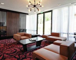 Lobby workspace with sofas at the Hampton by Hilton Toulouse Airport.