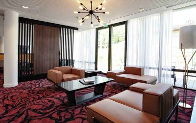 Lobby workspace with sofas at the Hampton by Hilton Toulouse Airport.