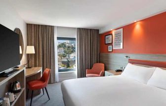 luxurious king suite with TV and work space at Hampton by Hilton Torquay.